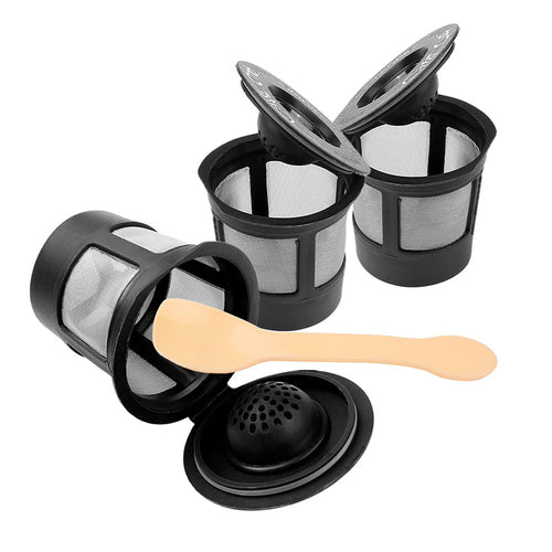 Three reusable coffee filter pods with a stainless steel spoon, made of durable materials, ideal for eco-friendly coffee brewing.