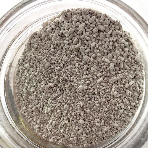 Detox bath Epsom salt clay essential oil soak with white salts, green clay, and amber essential oils on a wooden surface.